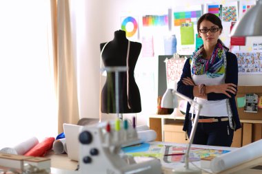 Güzel moda tasarımcısı stüdyoda duruyor.