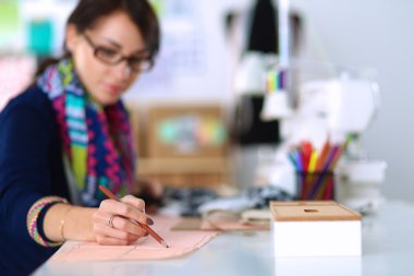Giysi tasarımcısı kağıt üzerinde kıyafet deseni tasarlıyor