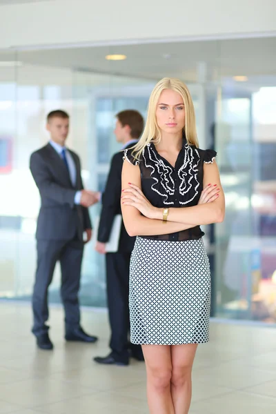 Portret van jonge zakenvrouw in functie met collega 's op de achtergrond — Stockfoto