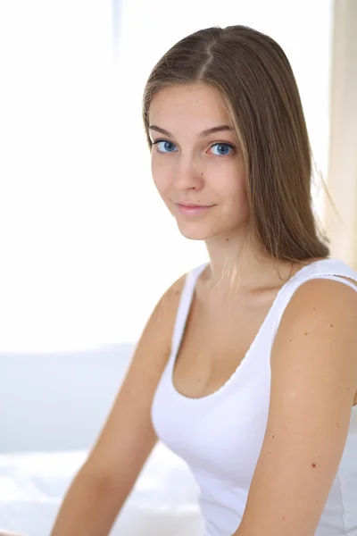 A pretty young woman sitting in bed — Stock Photo, Image