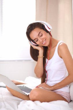 Genç güzel kadın yatakta müzik