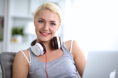 Evdeki genç ve güzel kadın kanepede oturup müzik dinliyor.