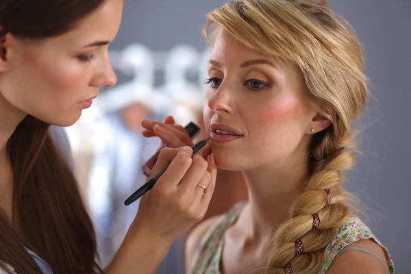 Kunstenaar doet professionele make-up van vrouw — Stockfoto