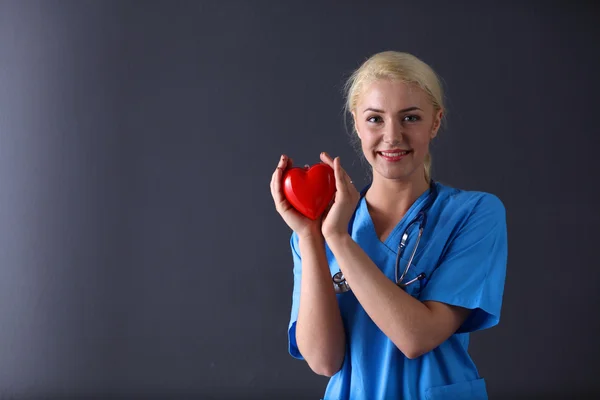 Доктор со стетоскопом держит сердце — стоковое фото