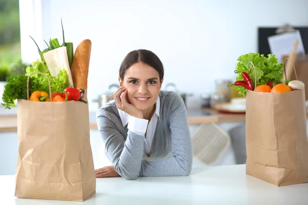 Portrait of a smiling woman cooking in her kitchen sitting — Stock Photo, Image