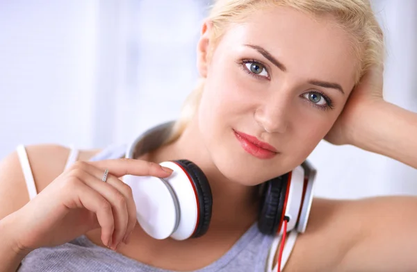 Young beautiful woman at home sitting on sofa and listening music — Stock Photo, Image