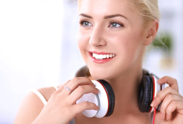 Young beautiful woman at home sitting on sofa and listening music — Stock Photo, Image