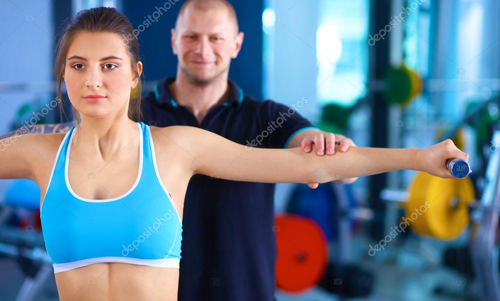 Sports Young Woman Doing Exercises on Trainer Back Machine in the