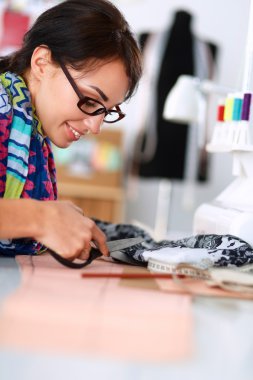 Çalışırken dikiş diken genç bir kadın.