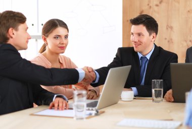 İş adamları iş toplantısında, ofiste oturup tartışıyorlar.