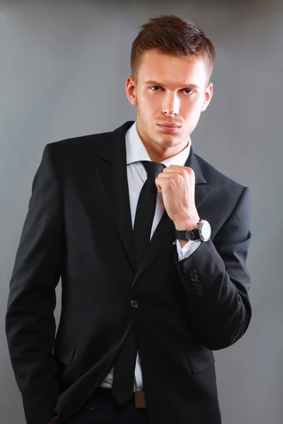 Portret udanego biznesu młodego człowieka stojącego na tle szarym tle — Zdjęcie stockowe