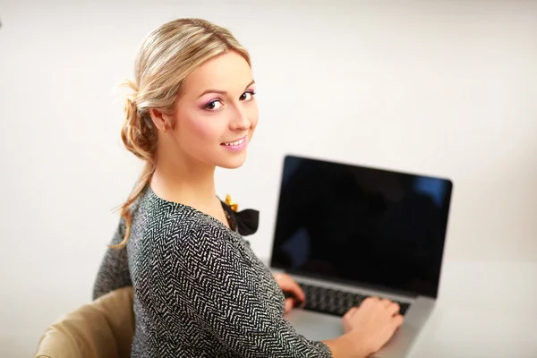 Um retrato de uma mulher de negócios sentada em uma mesa com um laptop — Fotografia de Stock