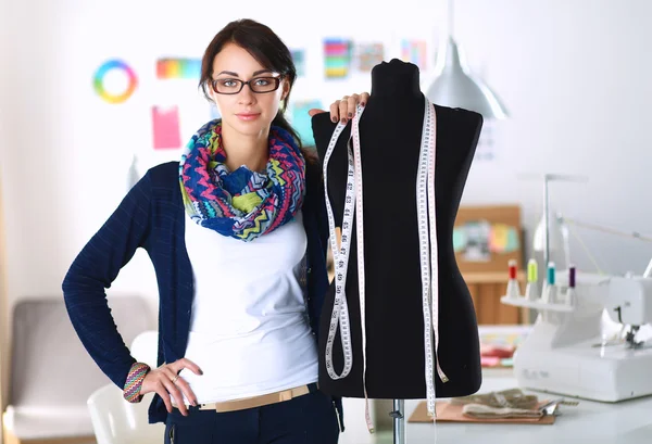 Uśmiechnięty projektant mody stoi w pobliżu manekina w biurze — Zdjęcie stockowe