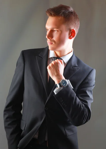 Porträtt av en framgångsrik ung affärsman står isolerat på grå bakgrund — Stockfoto