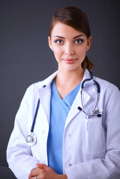 Mujer doctora con estetoscopio aislado sobre fondo gris — Foto de Stock