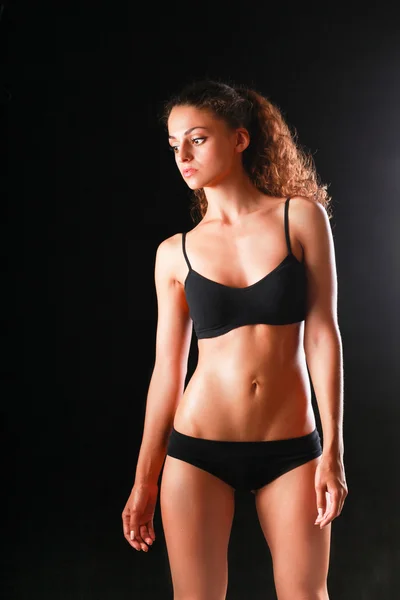 Portrét mladé krásné fitness ženy, izolované na černém pozadí — Stock fotografie