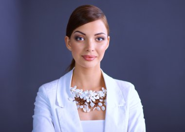 Boncuklar, gri arka plan üzerinde duran genç kadın portresi