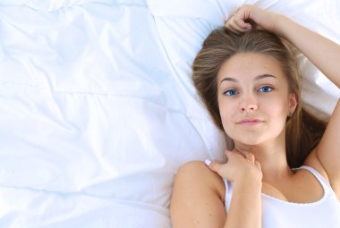 Yatakta rahat ve mutlu bir şekilde yatan güzel bir genç kadın.
