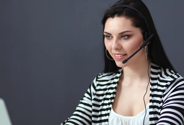 Mooie zakenvrouw werken aan haar bureau met headset en laptop — Stockfoto
