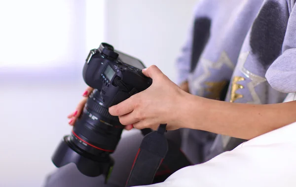 Vrouw zitten op een sofa in haar huis met camera — Stockfoto