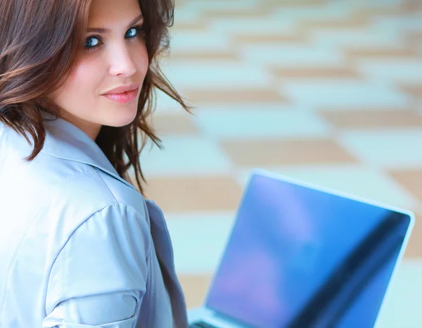 Giovane donna sorridente seduta con computer portatile — Foto Stock