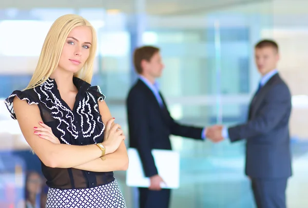 Portret van jonge zakenvrouw in functie met collega 's op de achtergrond — Stockfoto