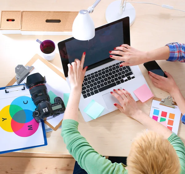 Vrouwelijke fotograaf zittend op het bureau met laptop — Stockfoto