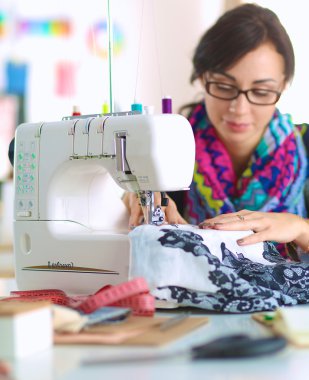 Çalışırken dikiş diken genç bir kadın.