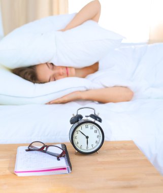 Genç bir kadın sabah alarmını erteliyor.