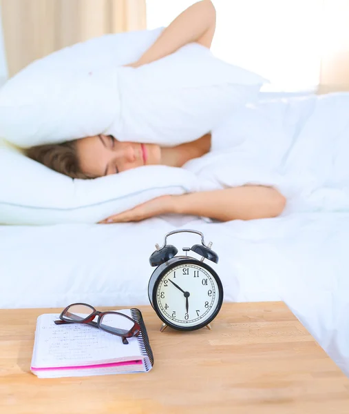 Una giovane donna che disattiva la sveglia la mattina — Foto Stock