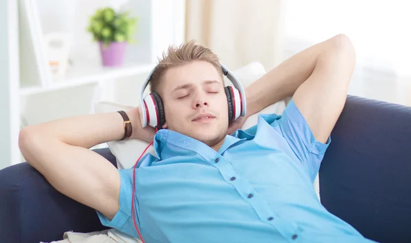 Homem ouvindo música com fones de ouvido em casa — Fotografia de Stock