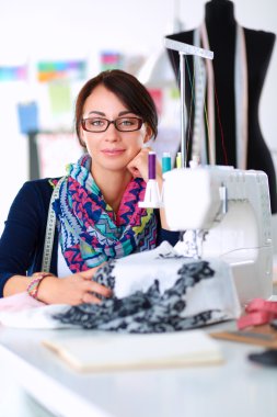 Çalışırken dikiş diken genç bir kadın.