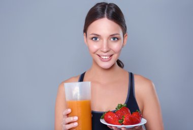 Vejetaryen sebze salatasıyla gülümseyen genç bir kadının portresi.