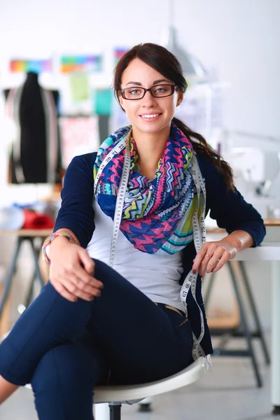 Mooie modeontwerper zit aan het bureau in studio — Stockfoto