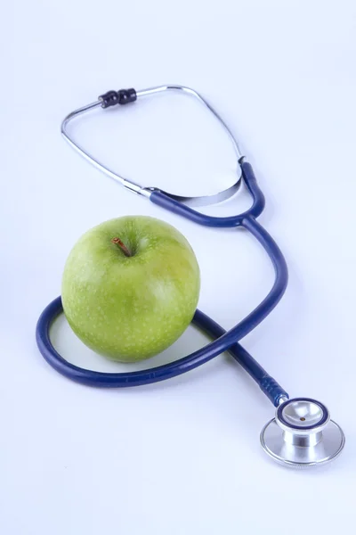 白い背景に隔離された医療用聴診器とリンゴ — ストック写真