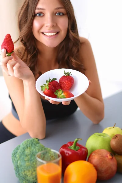 Girl sitting in the kitchen on the desk with fruit — Stock Photo, Image