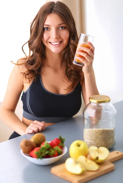 Menina sentada na cozinha na mesa com frutas e óculos com suco — Fotografia de Stock