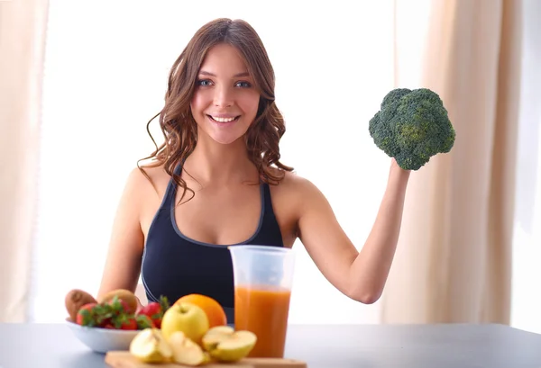 Junge und schöne Frau kocht in einer Küche — Stockfoto