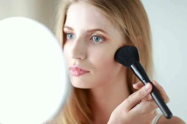 Pretty woman applying make up with brush — Stock Photo, Image