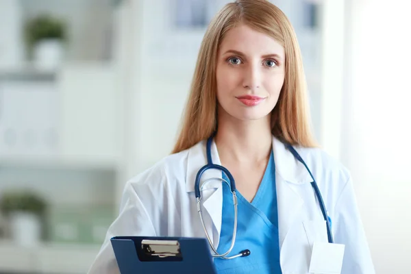 La doctora está parada en la ventana cercana. — Foto de Stock