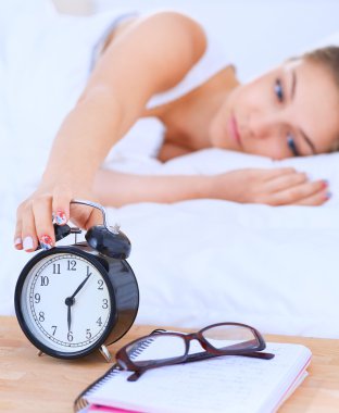 Genç bir kadın sabah alarmını erteliyor.