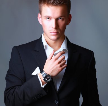 Gri arka plan üzerinde izole duran bir başarılı genç iş adamı portresi