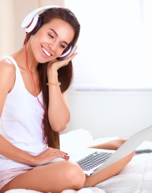 Genç güzel kadın yatakta müzik