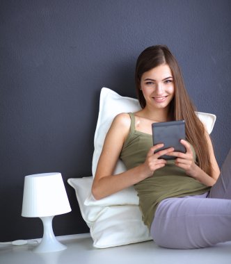 bir yastık ve uçak tablo ile katta oturan güzel esmer kadın