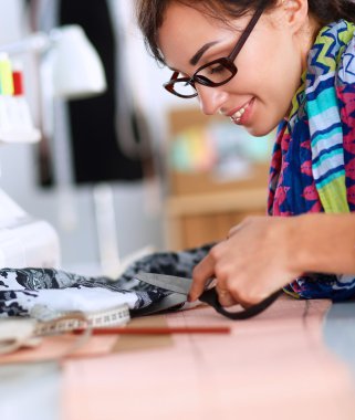 Çalışırken dikiş diken genç bir kadın.