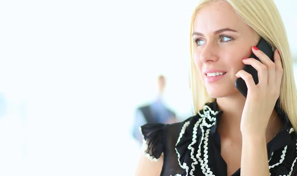 Beautiful businesswoman using cell phone , standing in office — Stock Photo, Image