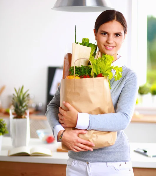 拿着蔬菜购物袋的年轻妇女。站在厨房里 — 图库照片