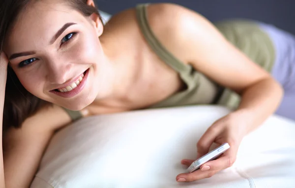 Mooie vrouw in haar woonkamer liggend op de bank verzenden puinhoop — Stockfoto