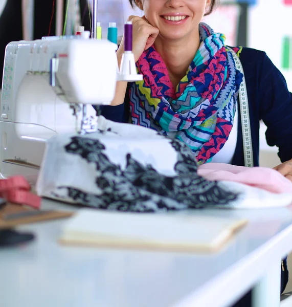 Mladá žena šití při sezení na svém pracovišti — Stock fotografie
