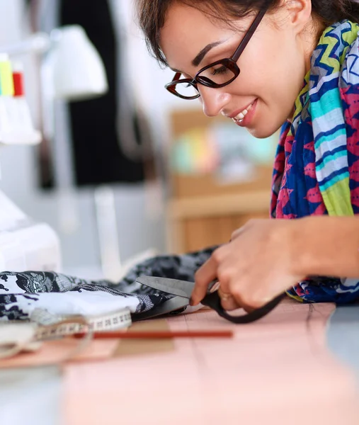 Mujer joven cosiendo sentado en su lugar de trabajo —  Fotos de Stock